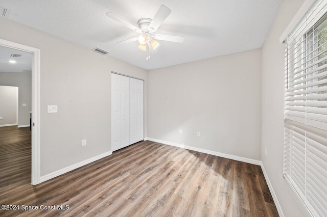 unfurnished bedroom with a closet, a textured ceiling, hardwood / wood-style flooring, and ceiling fan