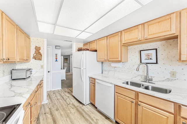 kitchen featuring light stone counters, light brown cabinetry, light wood-type flooring, sink, and white appliances