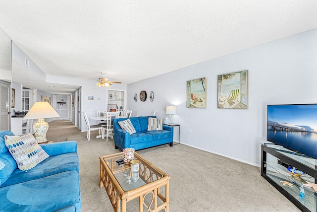 carpeted living room with a textured ceiling and ceiling fan