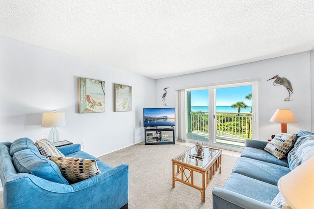 living room with a textured ceiling, carpet flooring, and a water view