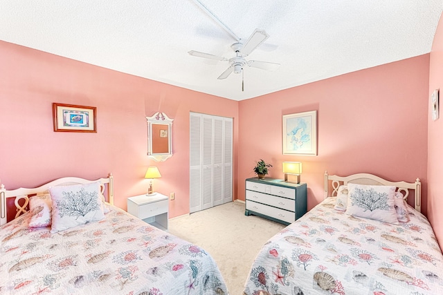 carpeted bedroom featuring a closet, ceiling fan, and a textured ceiling