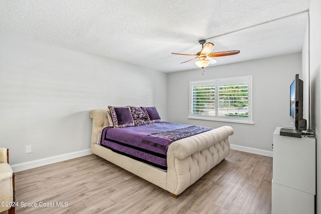 bedroom featuring ceiling fan, a textured ceiling, and light hardwood / wood-style flooring