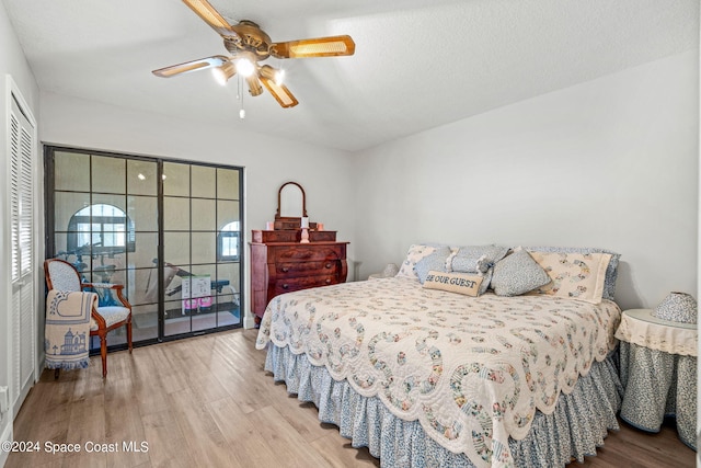 bedroom featuring access to outside, a textured ceiling, light hardwood / wood-style floors, and ceiling fan