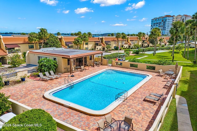 view of pool with a patio area and a yard