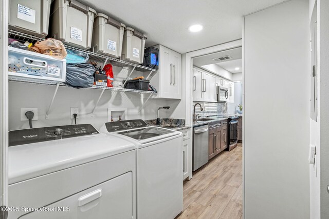 115 N Indian River Dr Unit 133, Cocoa, FL 32922 - laundry area featuring washer and clothes dryer, cabinet space, light wood-style floors, and recessed lighting