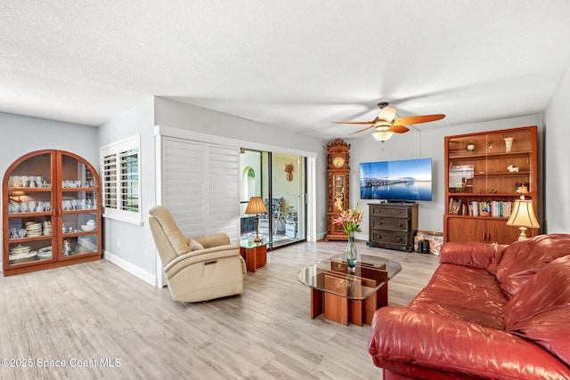 115 N Indian River Dr Unit 133, Cocoa, FL 32922 - living room with ceiling fan, wood finished floors, baseboards, and a textured ceiling