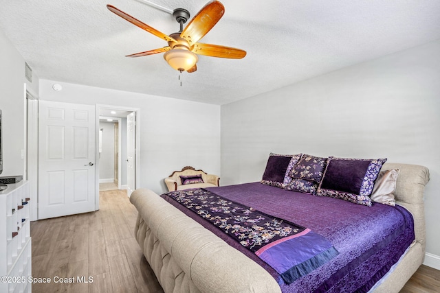 115 N Indian River Dr Unit 133, Cocoa, FL 32922 - bedroom with light wood-style floors, a textured ceiling, a ceiling fan, and baseboards