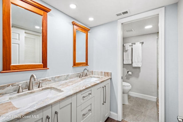 115 N Indian River Dr Unit 133, Cocoa, FL 32922 - full bathroom with double vanity, toilet, baseboards, and recessed lighting