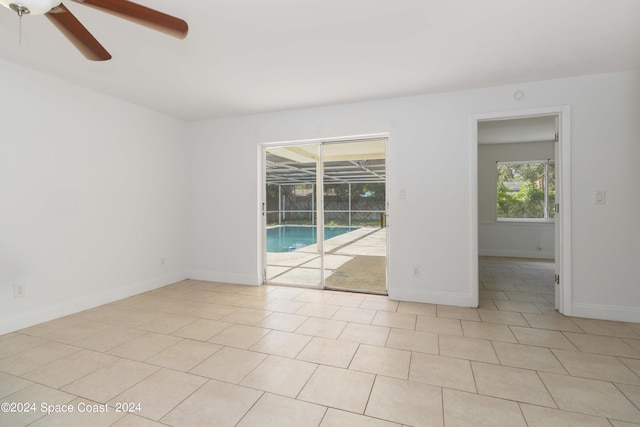 tiled spare room featuring ceiling fan