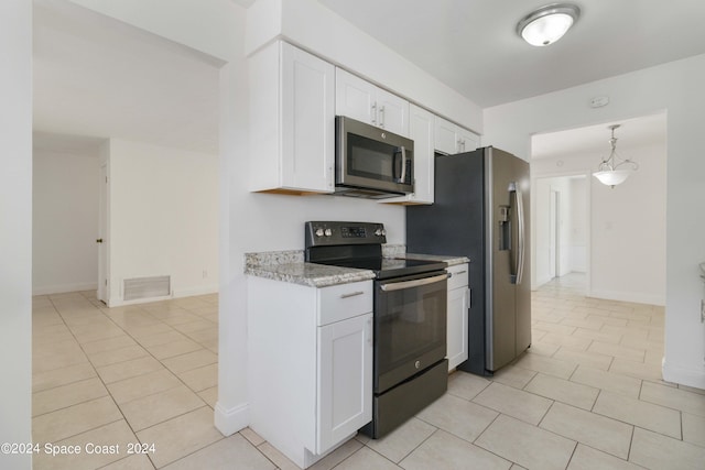 kitchen with white cabinets, appliances with stainless steel finishes, light tile patterned floors, and light stone counters