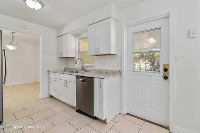 kitchen featuring white cabinetry, stainless steel appliances, light stone counters, sink, and light tile patterned flooring