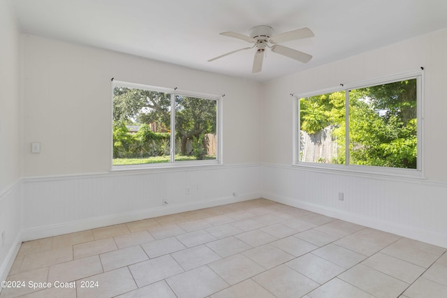 empty room with ceiling fan and light tile patterned floors