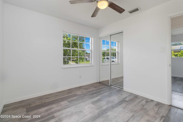 unfurnished bedroom with hardwood / wood-style floors, ceiling fan, and a closet