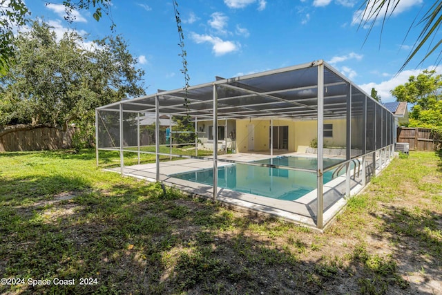 view of swimming pool featuring a patio area, a yard, and a lanai