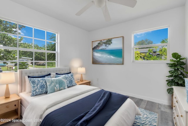 bedroom with multiple windows, hardwood / wood-style floors, and ceiling fan