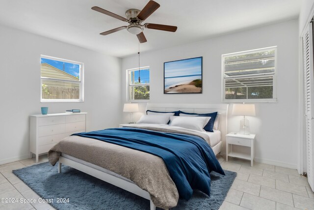 bedroom with ceiling fan and light tile patterned floors