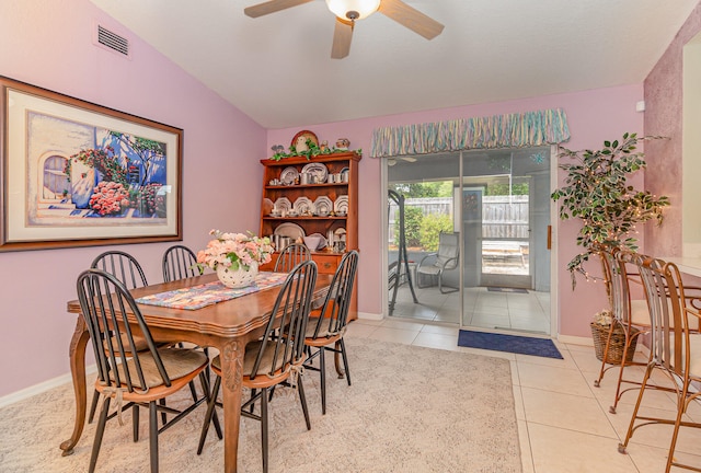 dining space featuring ceiling fan, lofted ceiling, and light tile floors