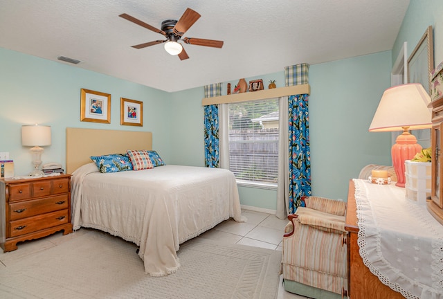 tiled bedroom featuring a textured ceiling and ceiling fan