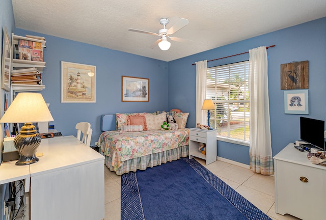 bedroom with ceiling fan, a textured ceiling, and light tile floors