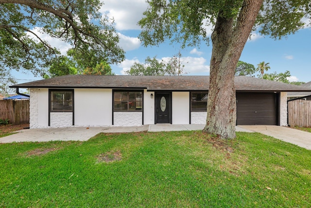 single story home featuring a garage and a front lawn