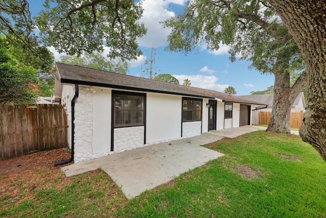 back of house featuring a patio area and a lawn