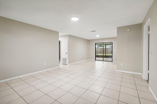 tiled spare room with a textured ceiling