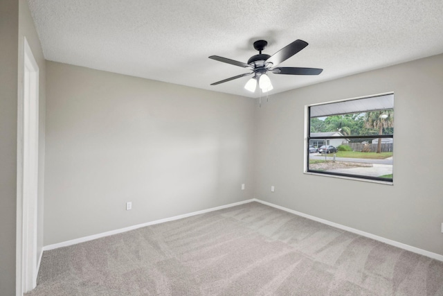 unfurnished room with a textured ceiling, carpet, and ceiling fan