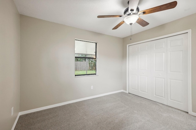 unfurnished bedroom with a closet, ceiling fan, and carpet floors