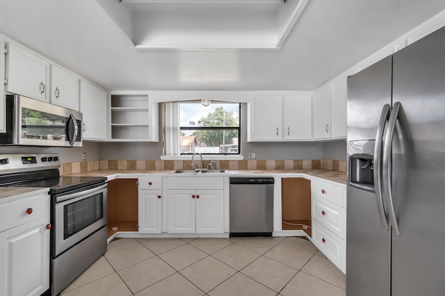 kitchen with sink, light tile flooring, white cabinetry, and appliances with stainless steel finishes