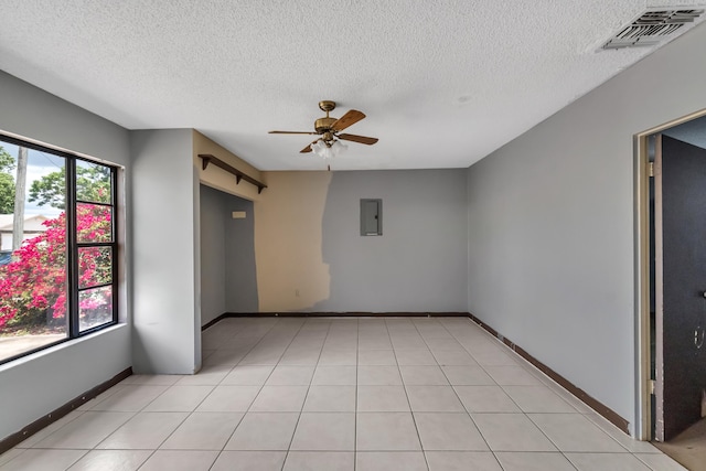 tiled spare room with ceiling fan and a textured ceiling