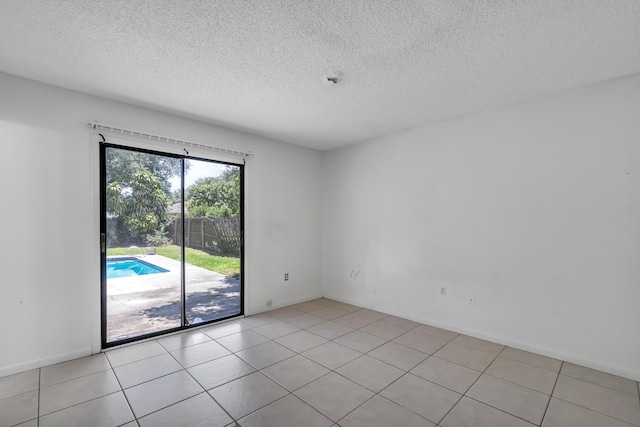 tiled empty room with a textured ceiling