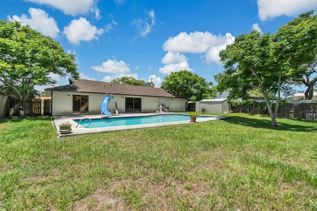 view of pool with a water slide and a yard