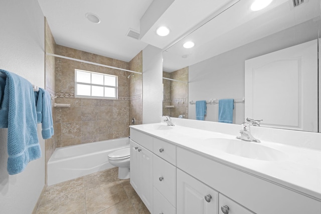 full bathroom featuring dual sinks, oversized vanity, tiled shower / bath, tile floors, and toilet