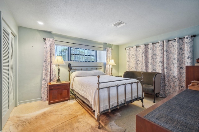 bedroom featuring carpet, a closet, and a textured ceiling