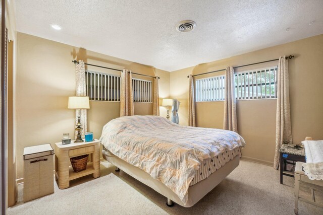 carpeted bedroom featuring a textured ceiling