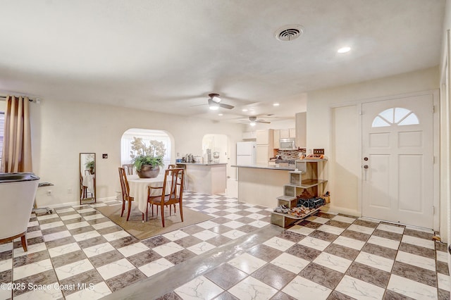 entrance foyer featuring baseboards, visible vents, arched walkways, and recessed lighting