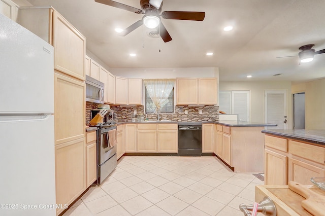 kitchen with ceiling fan, a peninsula, stainless steel appliances, light brown cabinetry, and a sink