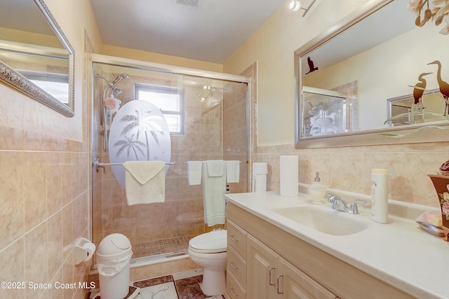 full bath featuring tile walls, visible vents, toilet, a shower stall, and vanity