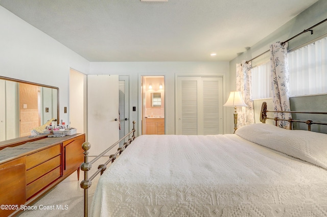 bedroom with light carpet and ensuite bath