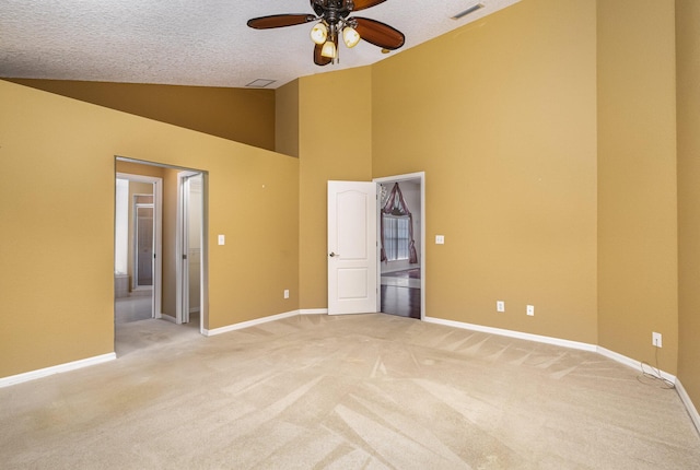 empty room with a textured ceiling, ceiling fan, light carpet, and high vaulted ceiling