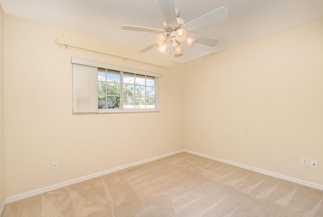 carpeted spare room featuring ceiling fan and a textured ceiling