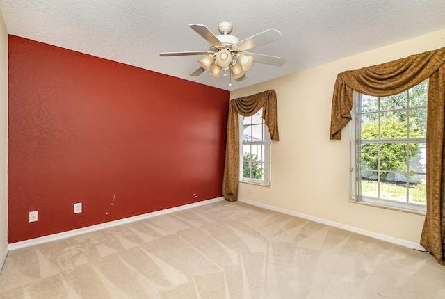 carpeted spare room with ceiling fan and a textured ceiling