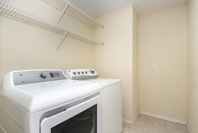 laundry room featuring light tile patterned flooring and separate washer and dryer