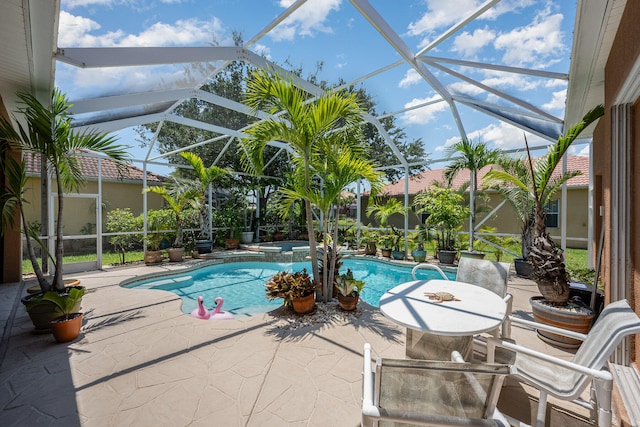 view of pool with a patio and glass enclosure