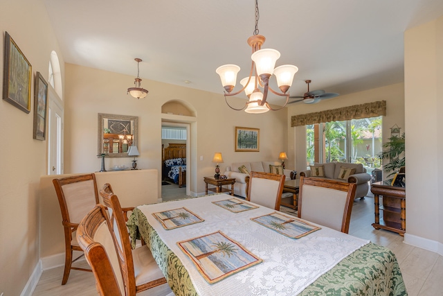 dining area featuring light hardwood / wood-style flooring and ceiling fan with notable chandelier