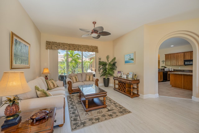 living room with light hardwood / wood-style flooring and ceiling fan