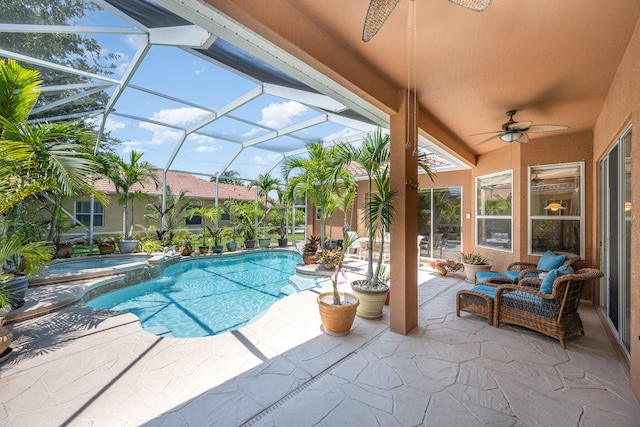 view of swimming pool featuring an in ground hot tub, glass enclosure, ceiling fan, and a patio area