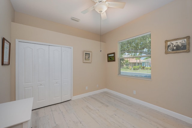 unfurnished bedroom with ceiling fan, a closet, and light hardwood / wood-style flooring