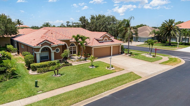 mediterranean / spanish-style house with a garage and a front lawn