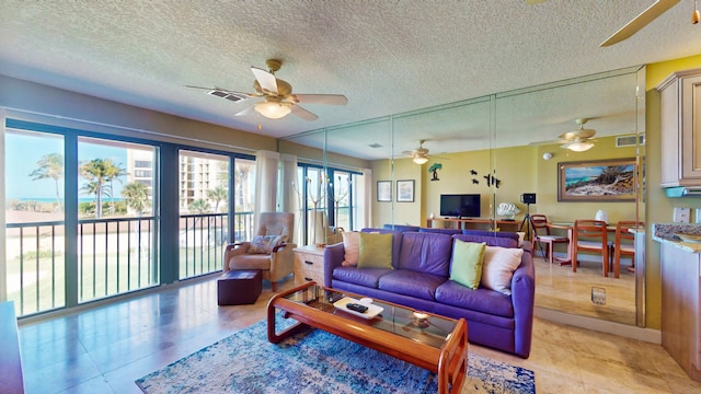 tiled living room featuring ceiling fan and a textured ceiling